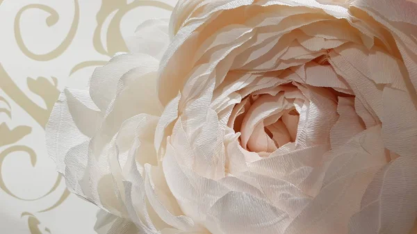 Tender white peony flower made from crepe paper. Soft paper peony petals closeup. Lush peony blossom for Valentines Day background. White wedding bouquet decorations. Beige textured floral backdrop