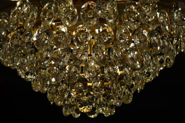 Soyut parlak cam dokusu yakın plan. Siyah arka planda lüks avizenin parlak kristal askıları. Klasik cam yüzey makrosu. Desenli arkaplan.