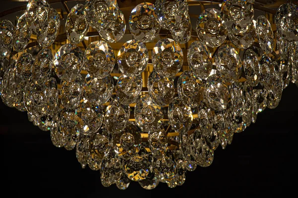 Jewelry style shiny glass texture closeup. Sparkle crystal hangings of luxury chandelier on black background. Vintage diamond shaped glass surface macro. Hexagon pattern backdrop.