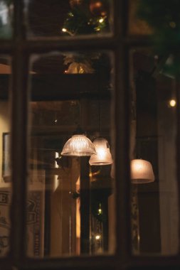 Camdaki eski ahşap çerçeveli soyut yansımaların bulanık arkaplanı. Beyaz retro abajurların bulanık yansıması ve altın gece ışıkları..