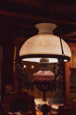 Eski gaz lambası. Eskimiş gaz lambası şeklinde, koyu bulanık arka planda beyaz lamba küre şeklinde Retro tarzı kolye ışığı. Antika metal detaylarıyla ışıklandırma ekipmanları asılıyor