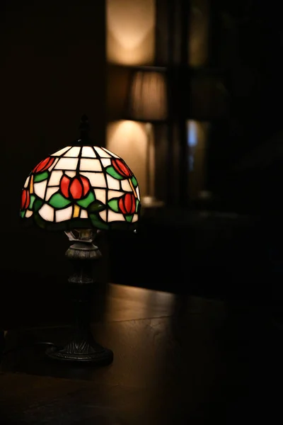 古色古香的台灯 玻璃灯罩在黑暗模糊的背景下的特写 闪烁着花纹花叶灯 古色古香的华丽灯罩 由色彩艳丽的玻璃片制成 — 图库照片