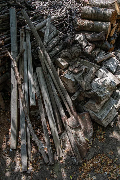 古い錆びた金属のシャベルと風化した薪の山のヒープ ざらざらした木の質感 コピースペース付きの素朴な背景 — ストック写真