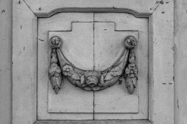 Eski ahşap kapı panelinde eski moda dekoratif dekoratif elementlerin siyah beyaz fotoğrafı. Avrupa 'nın klasik mimarisinde kirli beyaz kapı aralığının ayrıntılarını oymak