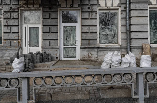 Залатанный Металлический Забор Перед Старым Каменным Зданием Новыми Белыми Окнами — стоковое фото