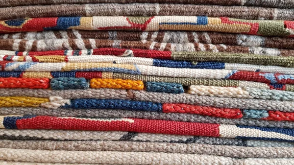 一堆叠好的土耳其传统地毯 五彩缤纷的地毯层叠在一起 机织纱线织成的背景 种族老式地毯的边缘 一堆手工制作的亚洲地板垫 土耳其集市背景 — 图库照片