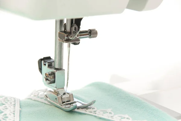 Шитье на бирюзовой ткани швейной машинки — стоковое фото