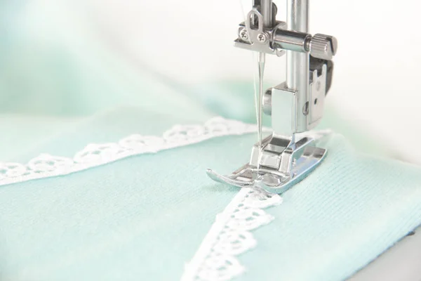 Шитье на бирюзовой ткани швейной машинки — стоковое фото