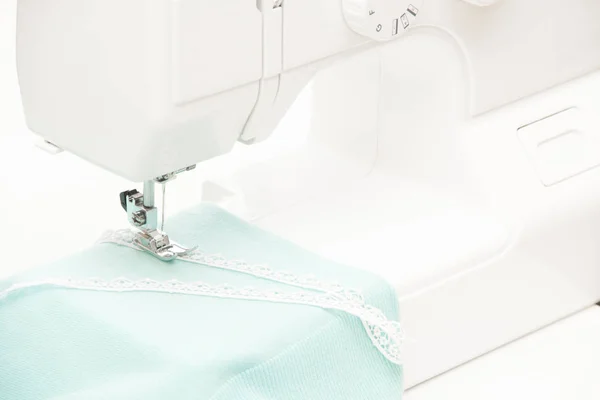 Het naaien op de naaimachine turquoise stof — Stockfoto