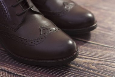 Yeni, orijinal deri ayakkabılar. Koyu arkaplanda bağcıkları olan yeni kahverengi deri ayakkabılar