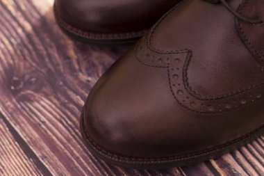 Yeni, orijinal deri ayakkabılar. Koyu arkaplanda bağcıkları olan yeni kahverengi deri ayakkabılar