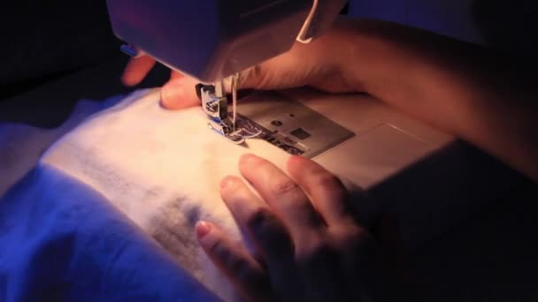 女性は暗い背景でミシンで縫っています 家庭での手作りのストレス — ストック動画