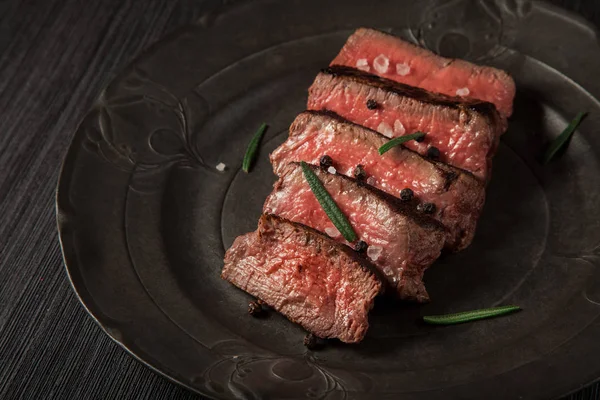 freshly prepared beef sirloin on a dark vintage plate background