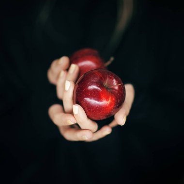 kırmızı elmalar holding kadın eller, şehvetli studio ile siyah artalan vurdu.