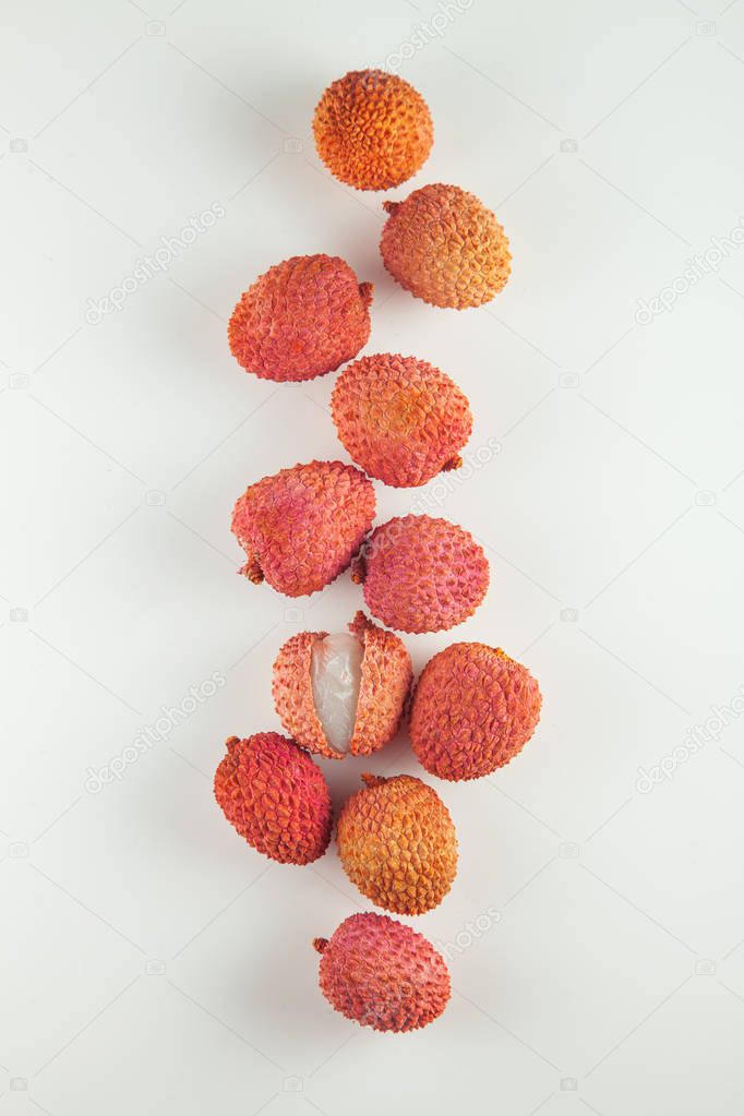 ripe, vermilion exotic lichees decorated on a white plate kitchen table background with napkin