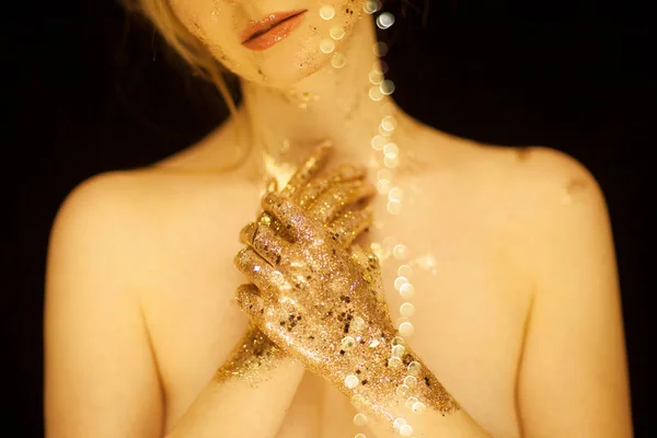 Beautiful woman in gold, golden hands, glitter sensual glamour studio shoot