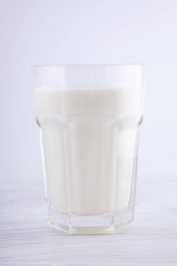 Beyaz mutfak ahşap plaka üzerinde bir bardak taze süt arka plan olarak kullanılabilir