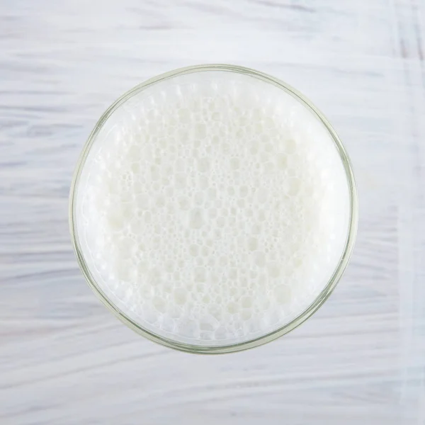 新鲜牛奶在玻璃上的白色厨房木板可以用作背景 — 图库照片