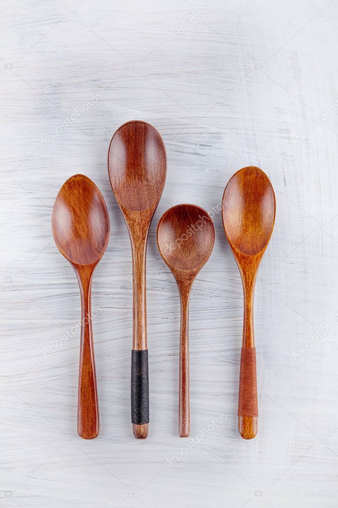 some wooden spoons decorated on white wood table can be used as background