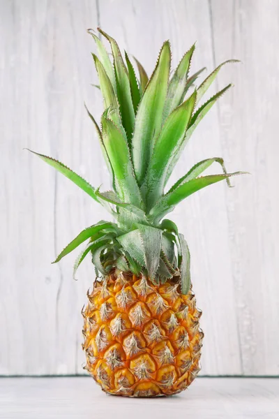 fresh ripe pineapple, rustic food photography on white wood plate kitchen table can be used as background