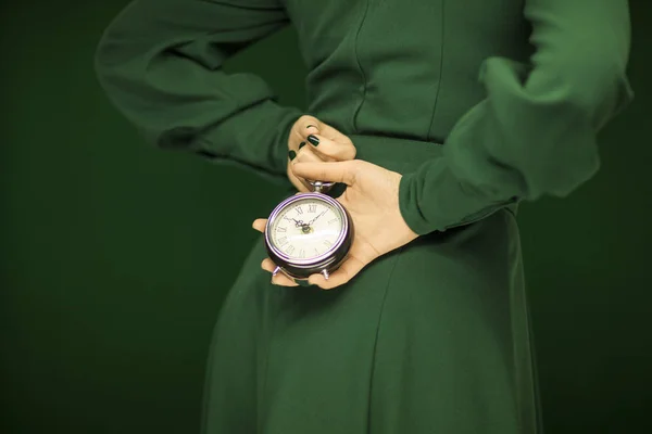 Красива Жінка Фігура Зеленій Сукні Зеленим Фоном Тримає Старовинний Годинник — стокове фото