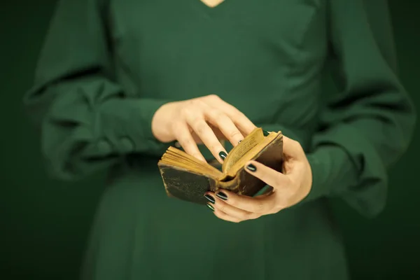 美丽的女人图在深绿色50的礼服持有复古书 手与绿色指甲油 — 图库照片