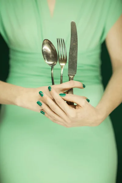 beautiful woman figure, bridesmaid in light green dress holding vintage cutlery, hands with green nail polish