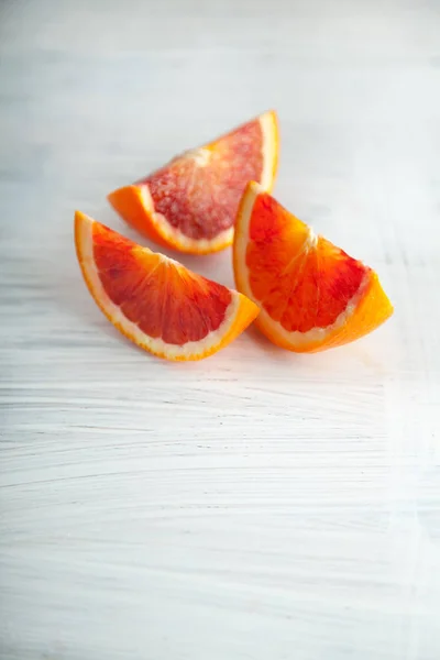 新鮮な熟したブラッド オレンジ スライス 白い木製プレート キッチン テーブルに素朴な料理写真が背景としても使えます — ストック写真