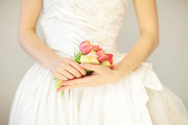 女性の花嫁手開催春の花チューリップとバラ 官能的なスタジオ ショットはバック グラウンドとして使用できます — ストック写真
