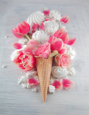Flatlay beyaz tahta arka plan üzerinde üstten görünüm tatlı dondurma koni pembe Gül ve Lale çiçeği çiçek ile waffle. Bahar ya da yaz ruh kavramı.
