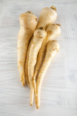 taze hasat maydanoz kökleri üzerinde beyaz ahşap mutfak plaka, arka plan olarak kullanılabilir