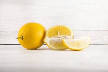 taze olgun limon, dilimleri, rustik gıda fotoğrafçılığı Beyaz ahşap plaka mutfak masasının üzerinde arka plan olarak kullanılabilir