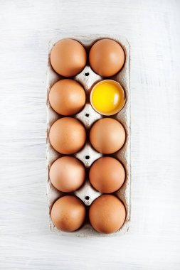 kahverengi tavuk yumurta bir yumurta sarısı görünür bir kutu, Beyaz ahşap rustik gıda fotoğrafçılık dekore edilmiş arka plan olarak kullanılabilir