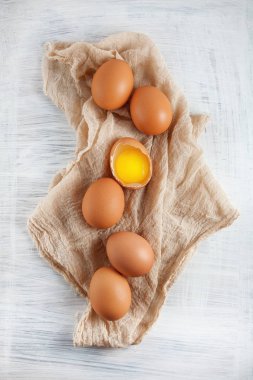 kahverengi tavuk yumurta bir yumurta sarısı görünür peçete, Beyaz ahşap rustik gıda fotoğraf üzerinde dekore edilmiş arka plan olarak kullanılabilir