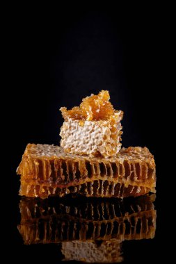 siyah arka planda, rustik gıda fotoğrafçılığı yansıtan bal ile parlak peteğin