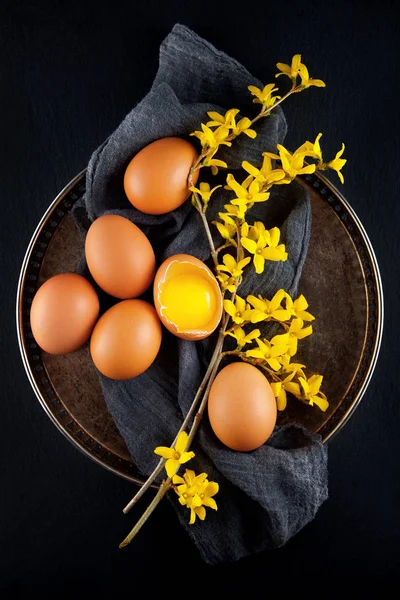 茶色の鶏の卵を飾るアンティーク プレート上黄色の花 素朴な料理写真が背景としても使えます — ストック写真