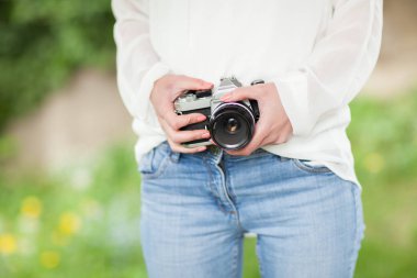 genç kadın el bir fotoğraf makinesi, görünüm açık, bahçede ellerinde tutan arka plan olarak kullanılabilir