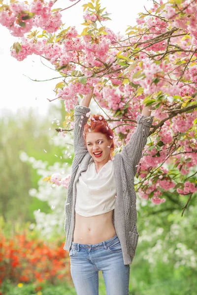 美丽的红色头发的年轻妇女有乐趣站立在樱桃开花树 春天庭院心情 — 图库照片