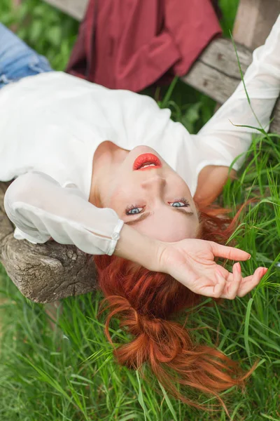 Молода Красива Жінка Рудим Волоссям Лежить Садовій Лавці Розслабляюча Зелена — стокове фото
