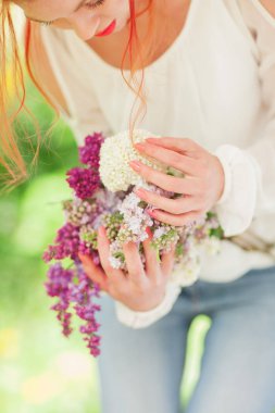 Beyaz ve mor Eflatun bloom açık Bahçe, onun elinde tutan Kızıl saçlı güzel kadın arka plan olarak kullanılabilir