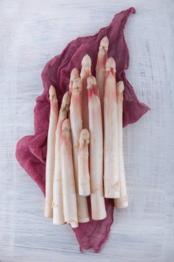 Beyaz kuşkonmaz bir beyaz tahta masada dekore edilmiş bir sürü, arka plan olarak kullanılabilir