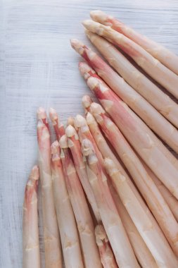 Beyaz kuşkonmaz bir beyaz tahta masada dekore edilmiş bir sürü, arka plan olarak kullanılabilir