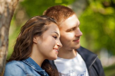 Eğleniyor, konuşurken, güneşli parkta ilkbaharda, güzel, romantik ruh hali flört genç Çift