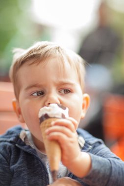 Küçük çocuk bir buz dışında bir masada, kapışma ruh parkta yemek