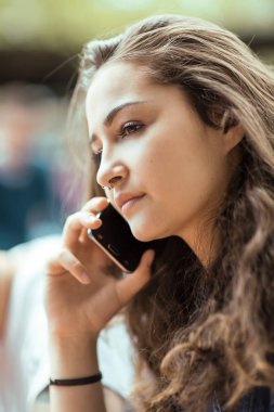 Onun cep telefonu, güneşli, kentsel mood bir sohbetin dışında oturan güzel genç kadın