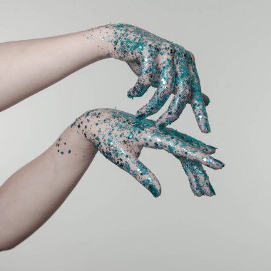 Siyah önünde mavi parıltılı güzel kadın elleri arka plan olarak kullanılabilir.