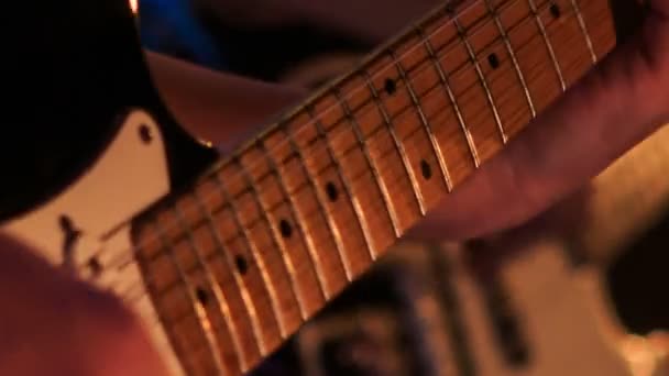 Guitarrista toca cuerdas en la guitarra — Vídeo de stock