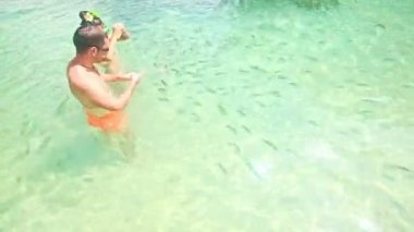 Adam kız şeffaf su izle çizgili balık akın