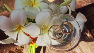 Şarap kadehi alyans beyaz çiçekler tarafından üstte devretmiştir