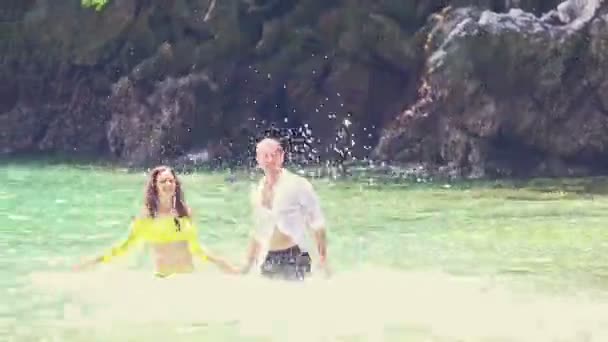 Kaukasische Braut in gelbem Bräutigam plantscht im azurblauen Meer — Stockvideo